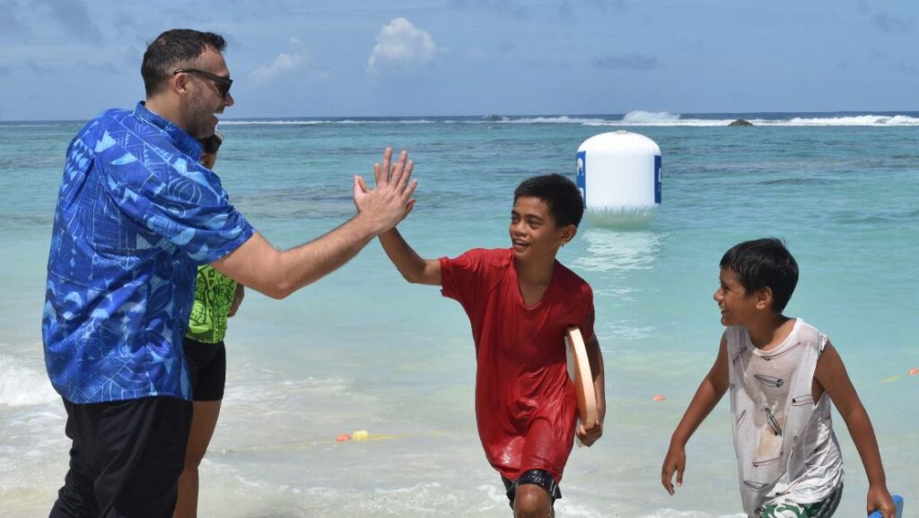 Ian “Thorpedo” Thorpe, an Australian Olympic Gold medallist and World Champion swimmer now retired, gives high fives to school kids in the Cook Islands Aquatics Federation (CIAF) programme yesterday at the Social centre beach
